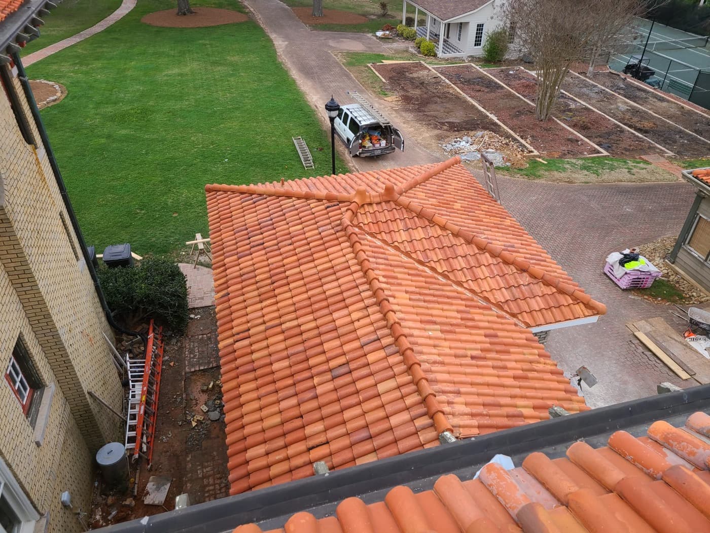 Spanish clay tile roof installation with ridge caps and hip detail on a Metro Atlanta estate